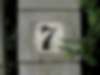 Abblätternde Hausnummer auf Pfosten mit Eibe in Bern